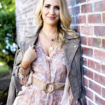 Blonde female leaning against a brick wall